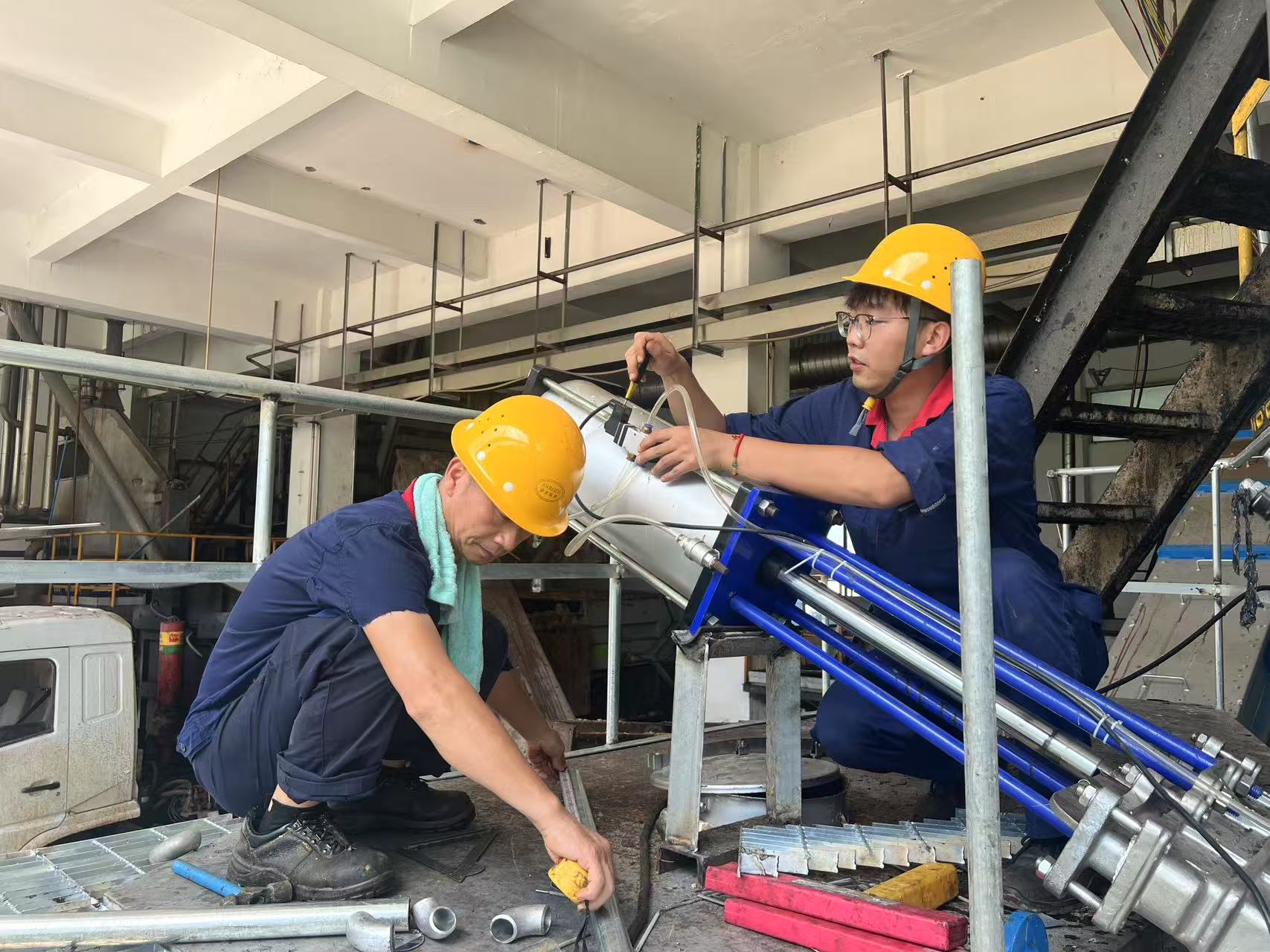 谌潇毅（右一）和同事在进行气动泵维修.jpg