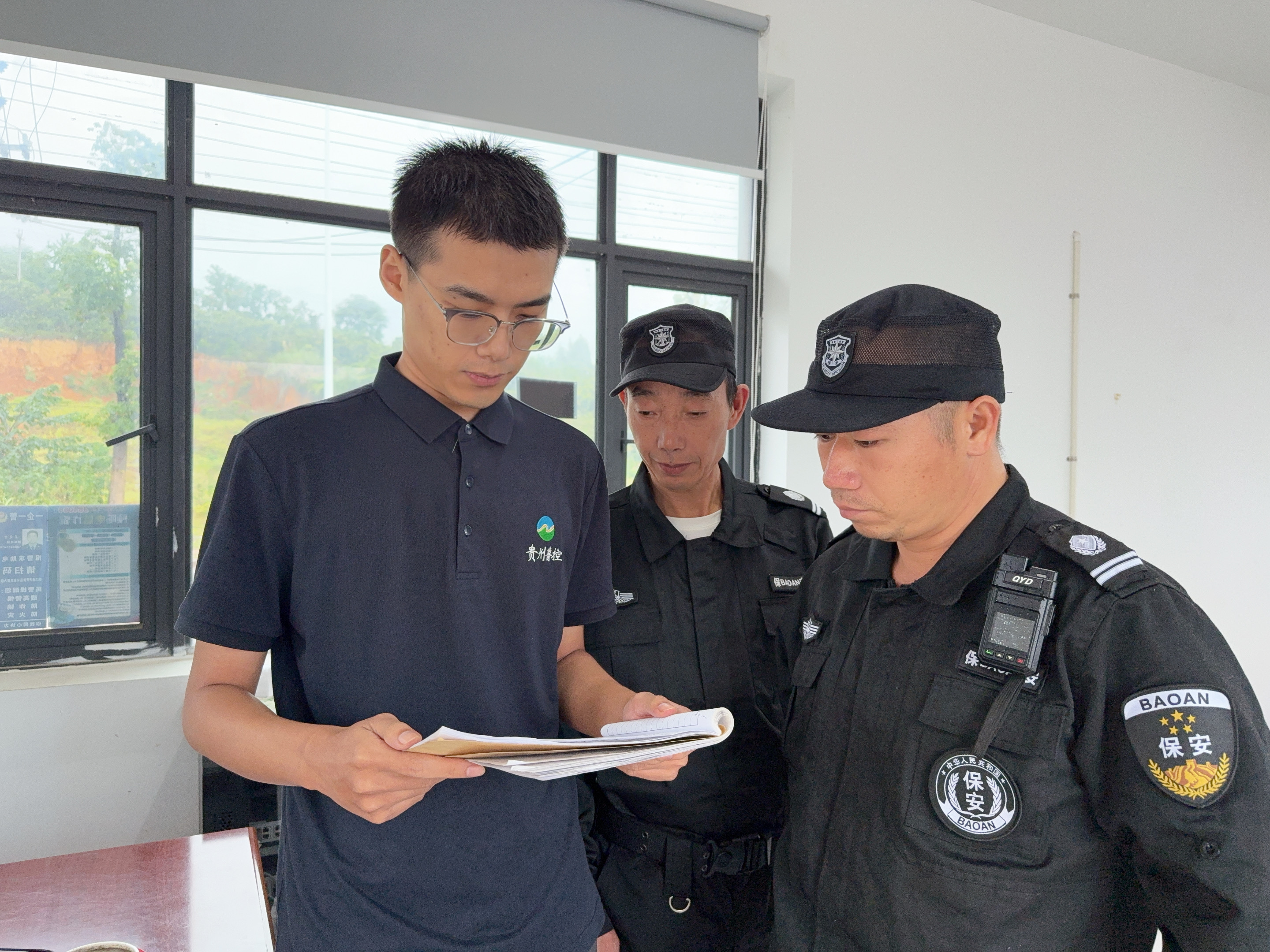 1760145610466.jpg 图为李鹏程检查进出车辆登记情况.jpg